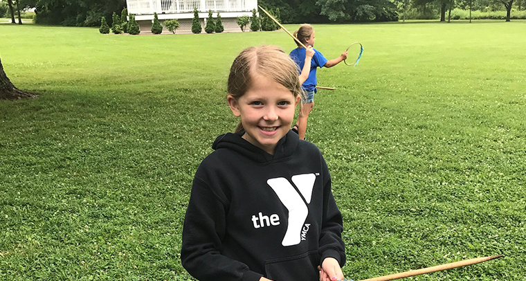 Smiling girl wearing YMCA sweatshirt outside